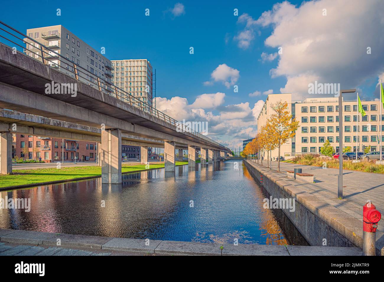 Canale con acqua sul viale Ã˜restad nella zona della città Ã˜restad. Sul ponte, metropolitana linea M1. Copenaghen , Danimarca Foto Stock