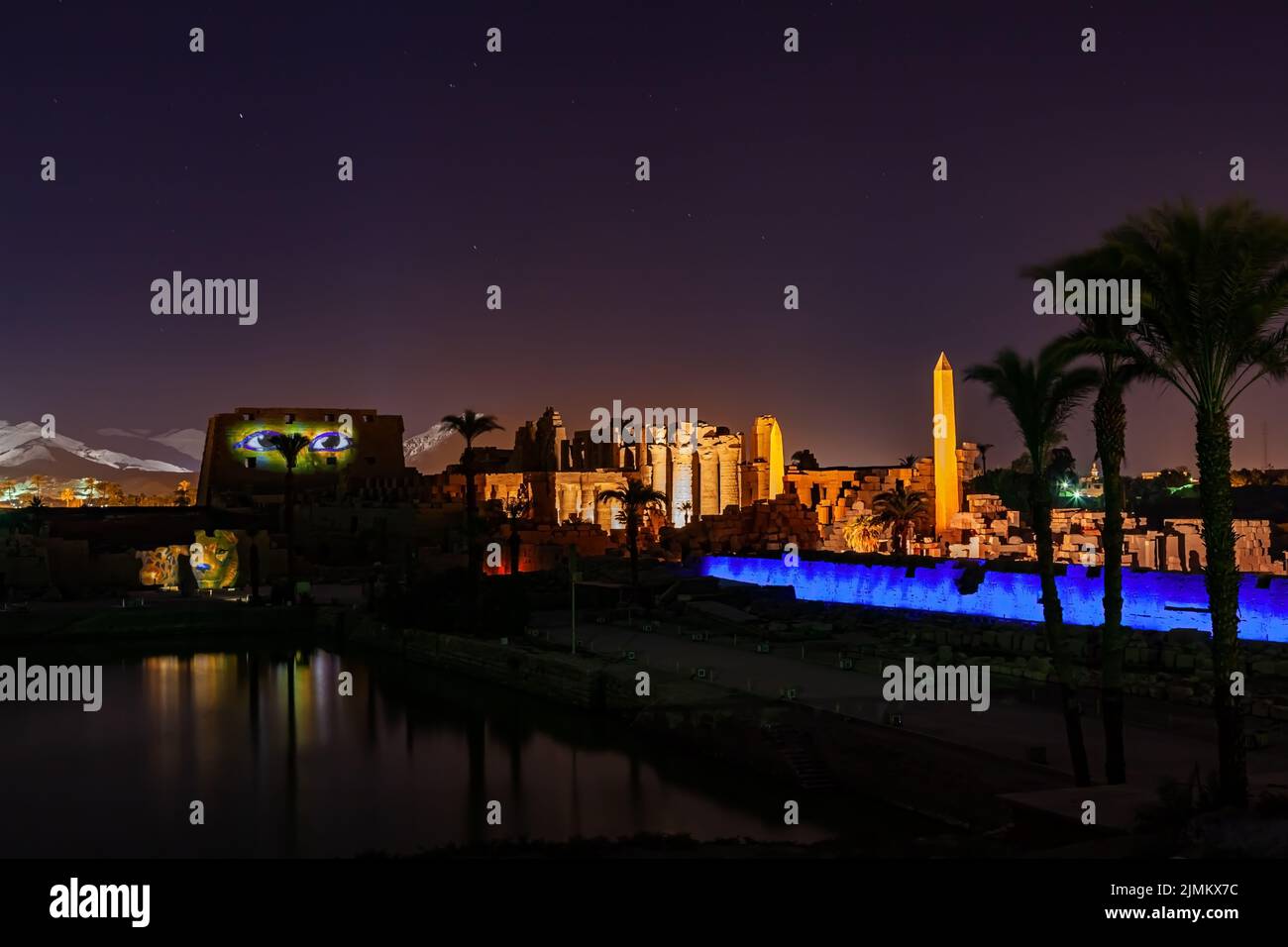 Complesso del Tempio di Karnak di notte con un alto obelisco e un lago sacro. Foto Stock