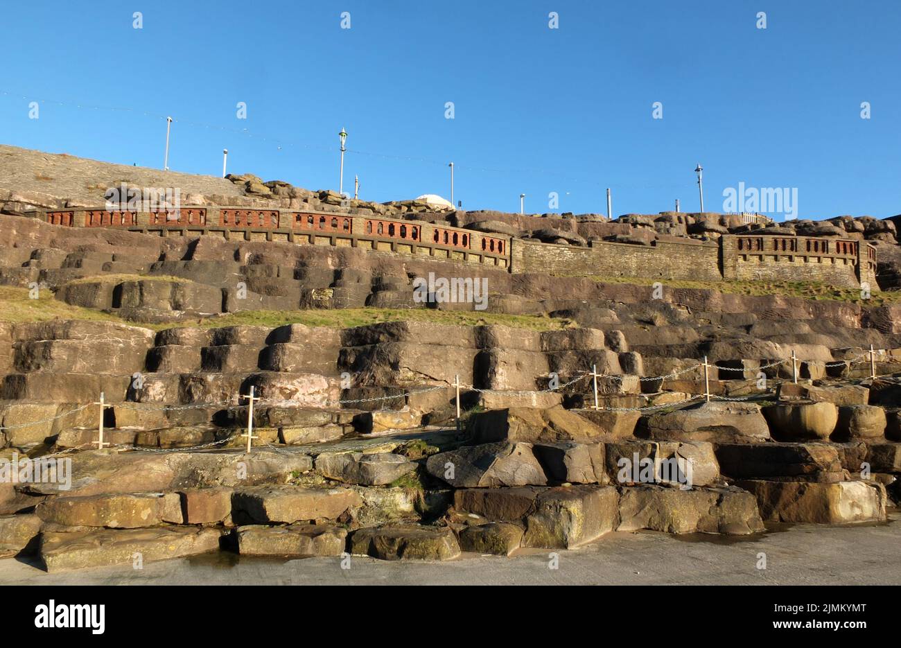 L'area delle scogliere di blackpool con rocce scolpite artificialmente e passerelle lungo il lungomare alla luce del sole del pomeriggio Foto Stock