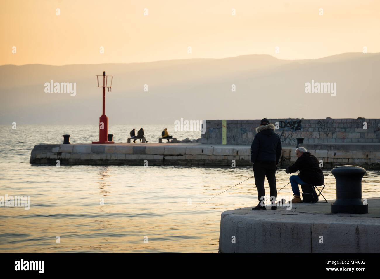 Pescatore con cappello su talpa di mare con canna di pesce. Foto Stock