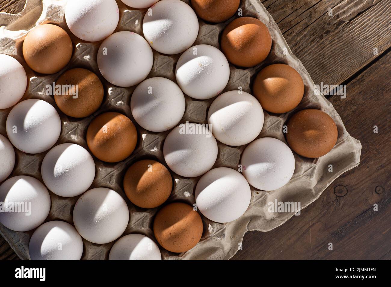 Sfondo uovo. Uova bianche e marroni in un vassoio della scatola di carta alimenti proteici. Eco biologico. Concetto di minimalismo. Foto Stock