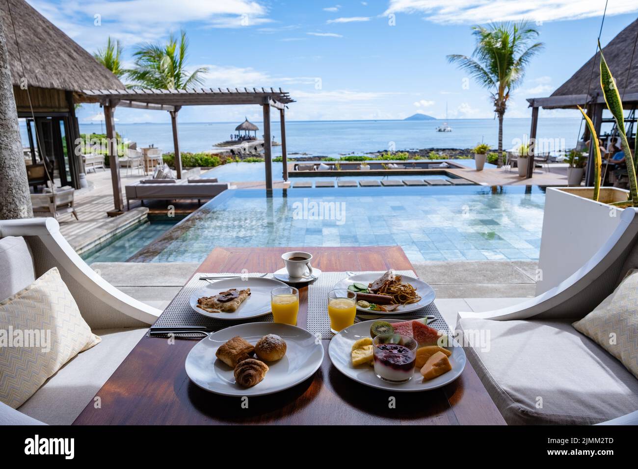 Prima colazione in spiaggia con palme e piscina a Mauritius, ambiente tropicale con prima colazione Foto Stock