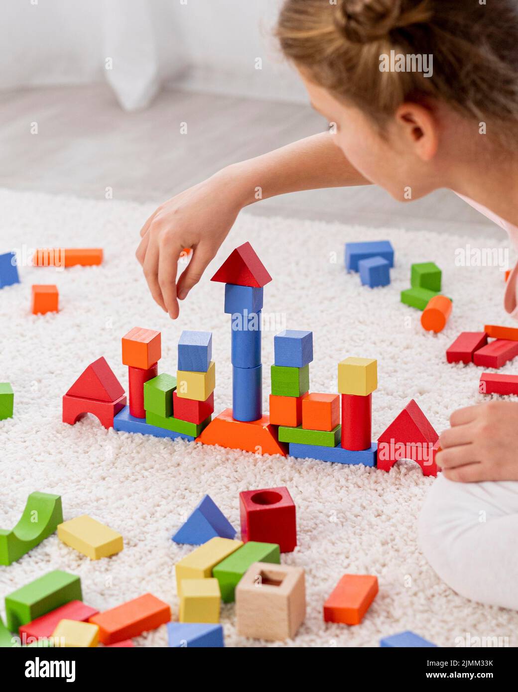 Bambini non binary che giocano con la casa colorata del gioco Foto Stock