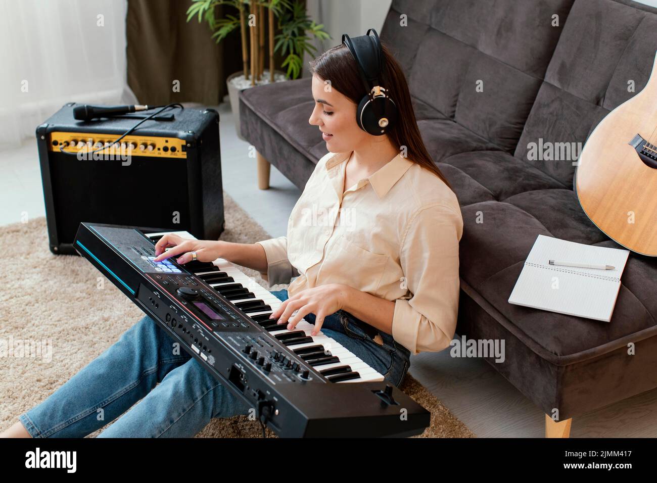 Musicista femminile ad angolo alto che suona la tastiera del pianoforte Foto Stock
