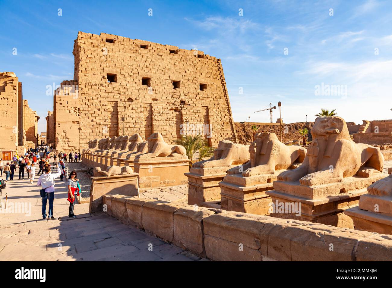 Persone che camminano all'ingresso del Tempio di Karnak in una giornata di sole. Foto Stock
