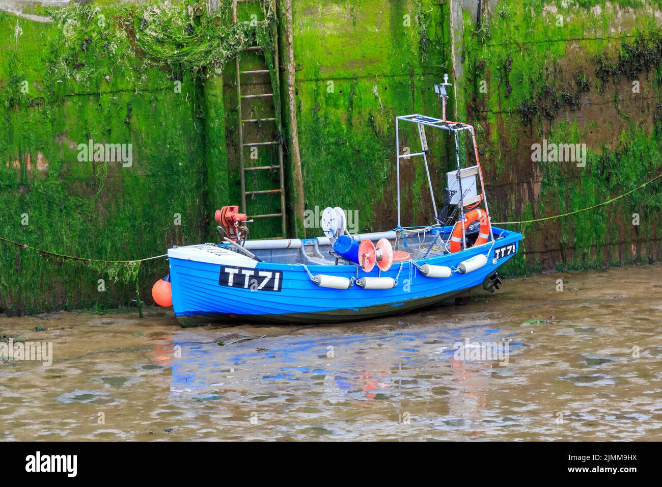 The , Isola di Whithorn, Scozia - Giugno, 13, 2022: Piccola barca da pesca blu ormeggiata dal porto con bassa marea Foto Stock