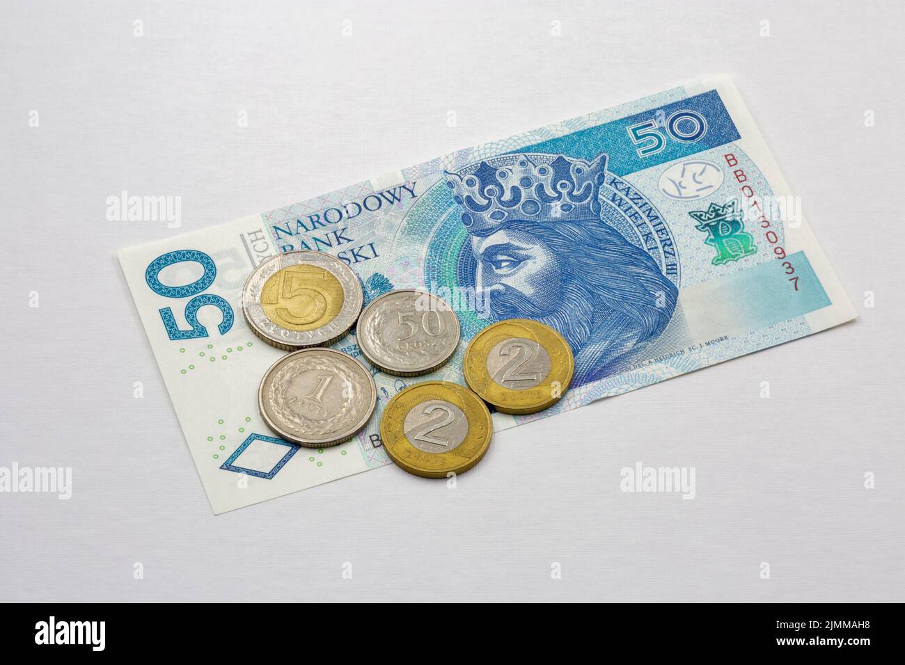 Banconote e monete polacche da cinquanta zloty in primo piano su bianco Foto Stock