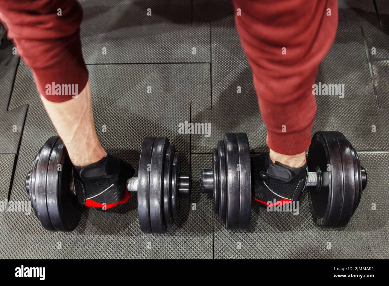 Atleta che prende manubri dal pavimento, uomo pov Foto Stock