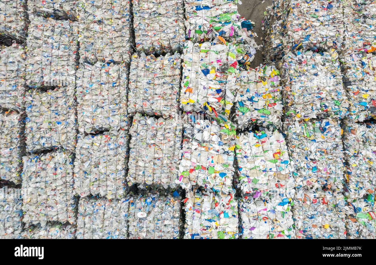 Vista aerea del materiale plastico spremuto recuperato in un impianto di smistamento in attesa di trasporto all'impianto di lavorazione. Tema riciclaggio rifiuti. Foto Stock