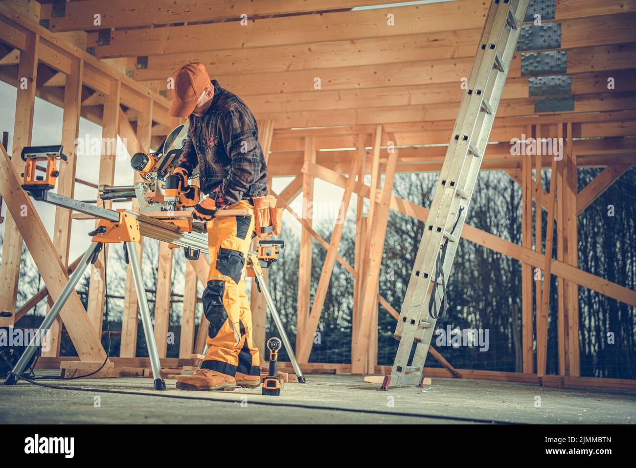 Lavoro caucasico taglio legno con sega circolare professionale attrezzatura preparazione elemento di legno per la costruzione di telaio Casa. Foto Stock