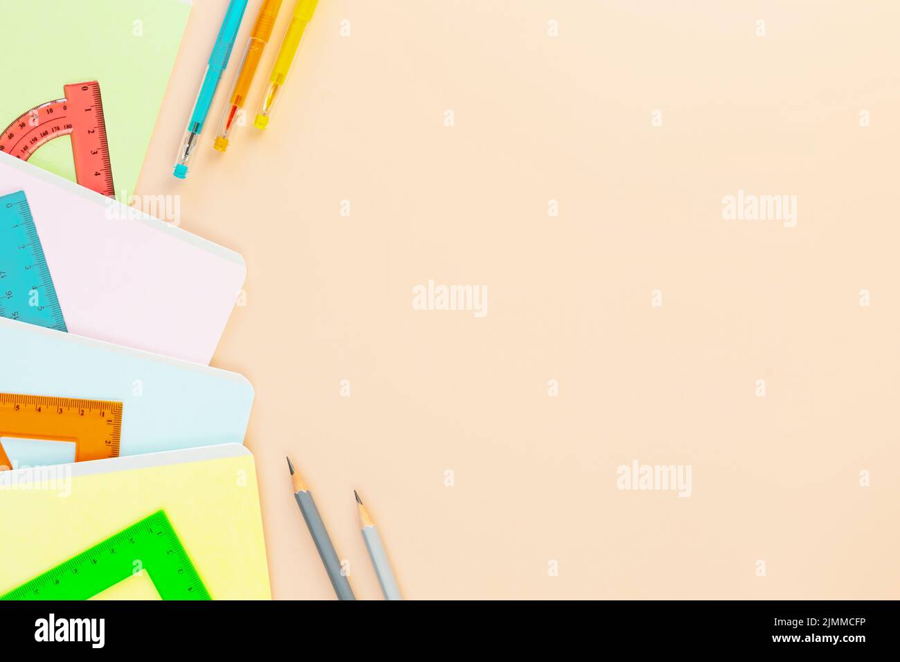 Ritorno a scuola con notebook, penne e righelli multicolore. Forniture scolastiche su sfondo avorio con spazio di copia. Concetto di vendita scolastica. FL Foto Stock