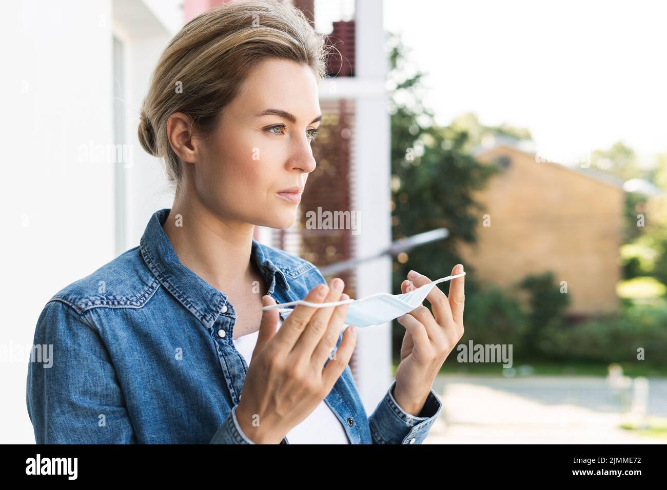 Donna con maschera di prevenzione sta andando fuori per prendere un respiro profondo Foto Stock