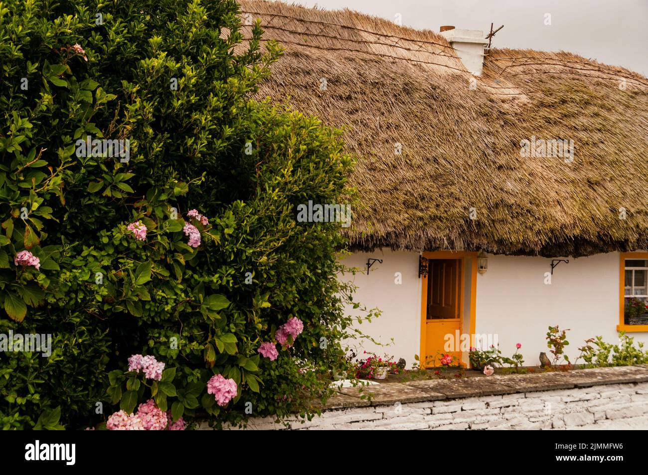 Cottage con tetto di paglia sulla strada per le scogliere di Moher in Irlanda. Foto Stock