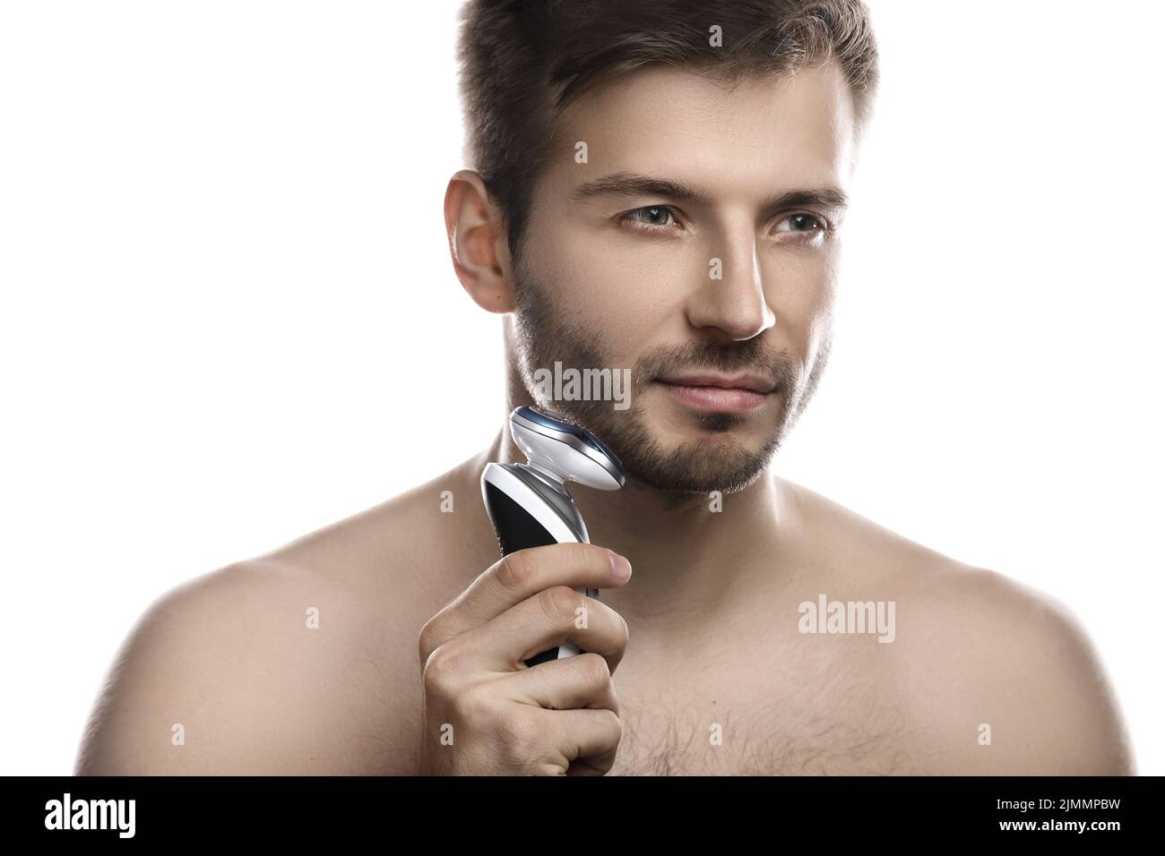 Un bell'uomo usa il rasoio elettrico su sfondo bianco Foto Stock