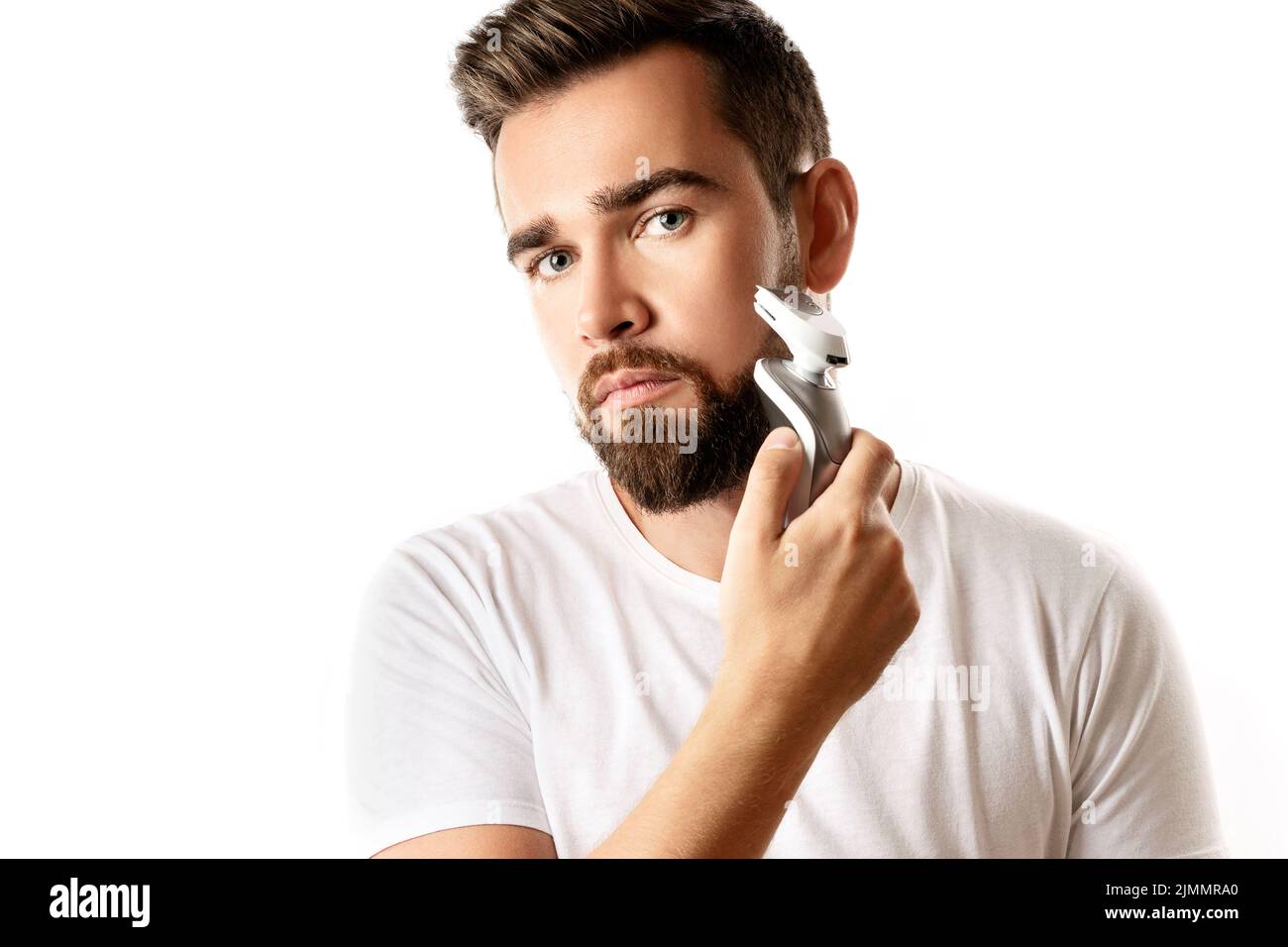 Bell'uomo bearded sta usando il tagliabasette elettrico Foto Stock