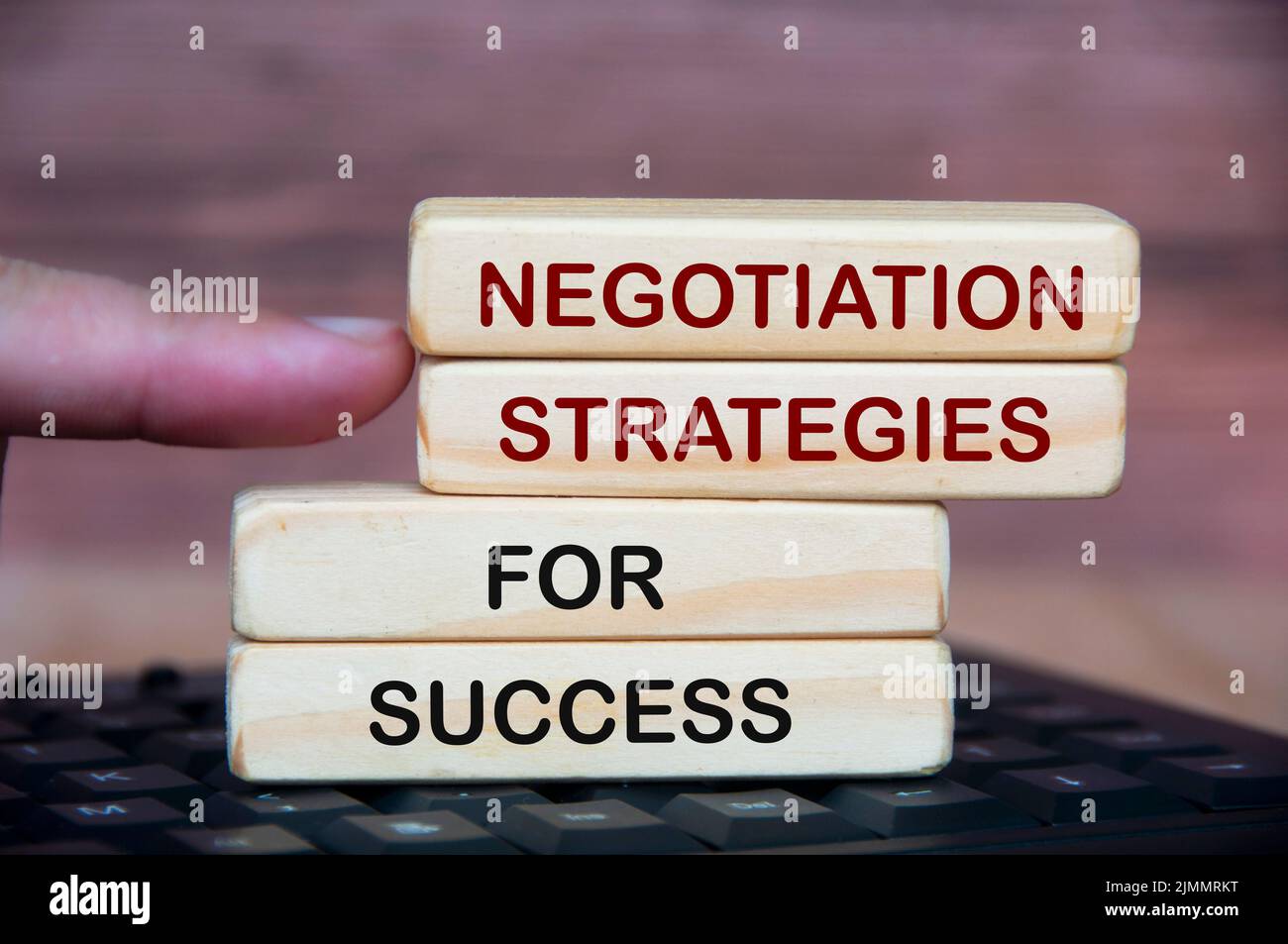 Strategie di negoziazione per il testo di successo su blocchi di legno. Con tastiera e sfondo in legno sfocato. Foto Stock