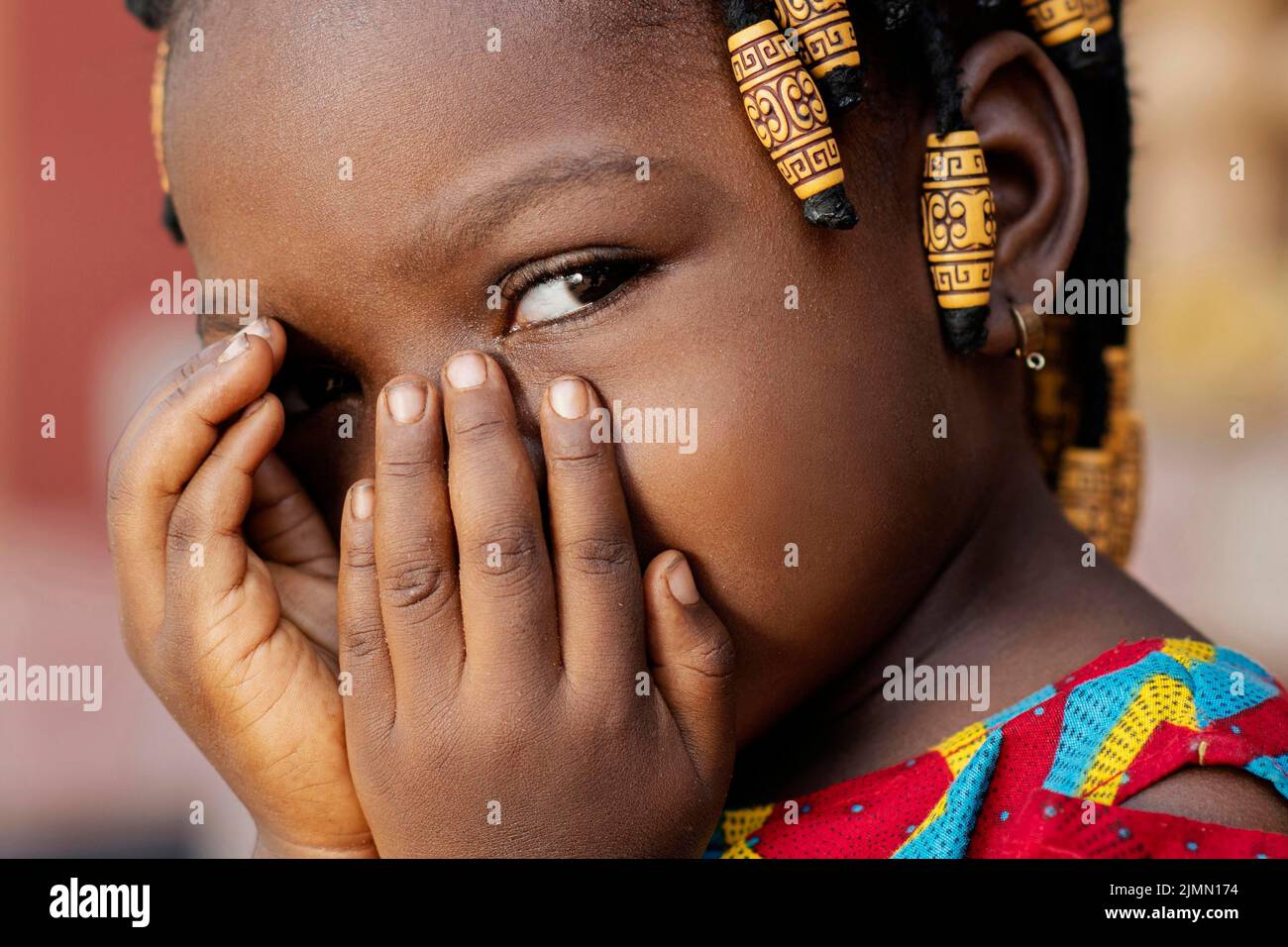 Primo piano ragazza africana che copre il suo volto Foto Stock