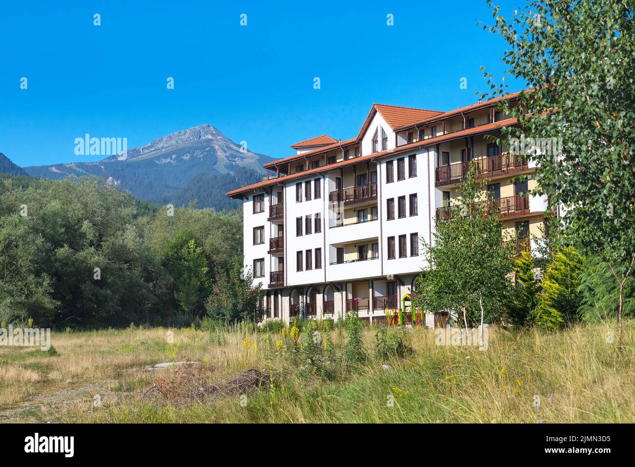 Case in legno chalet e panorama estivo montagne nella stazione sciistica bulgara Bansko, Bulgaria Foto Stock