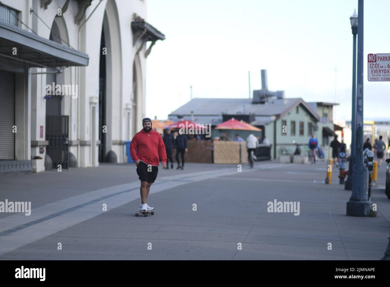 Un giovane barbuto che cavalca uno skateboard su una strada a San Francisco Foto Stock