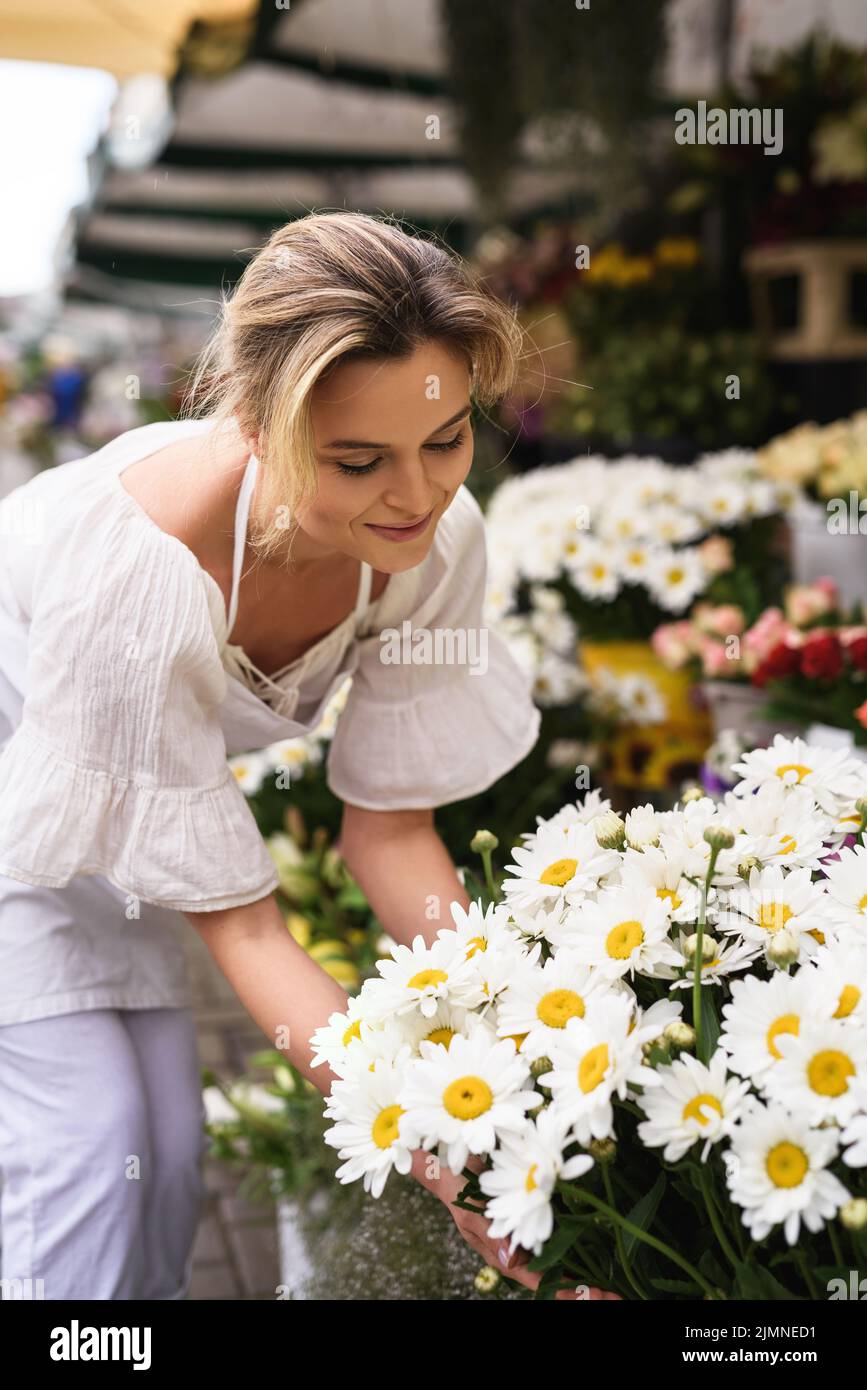 Bella fiorista donna che lavora nel suo piccolo negozio di fiori Foto Stock