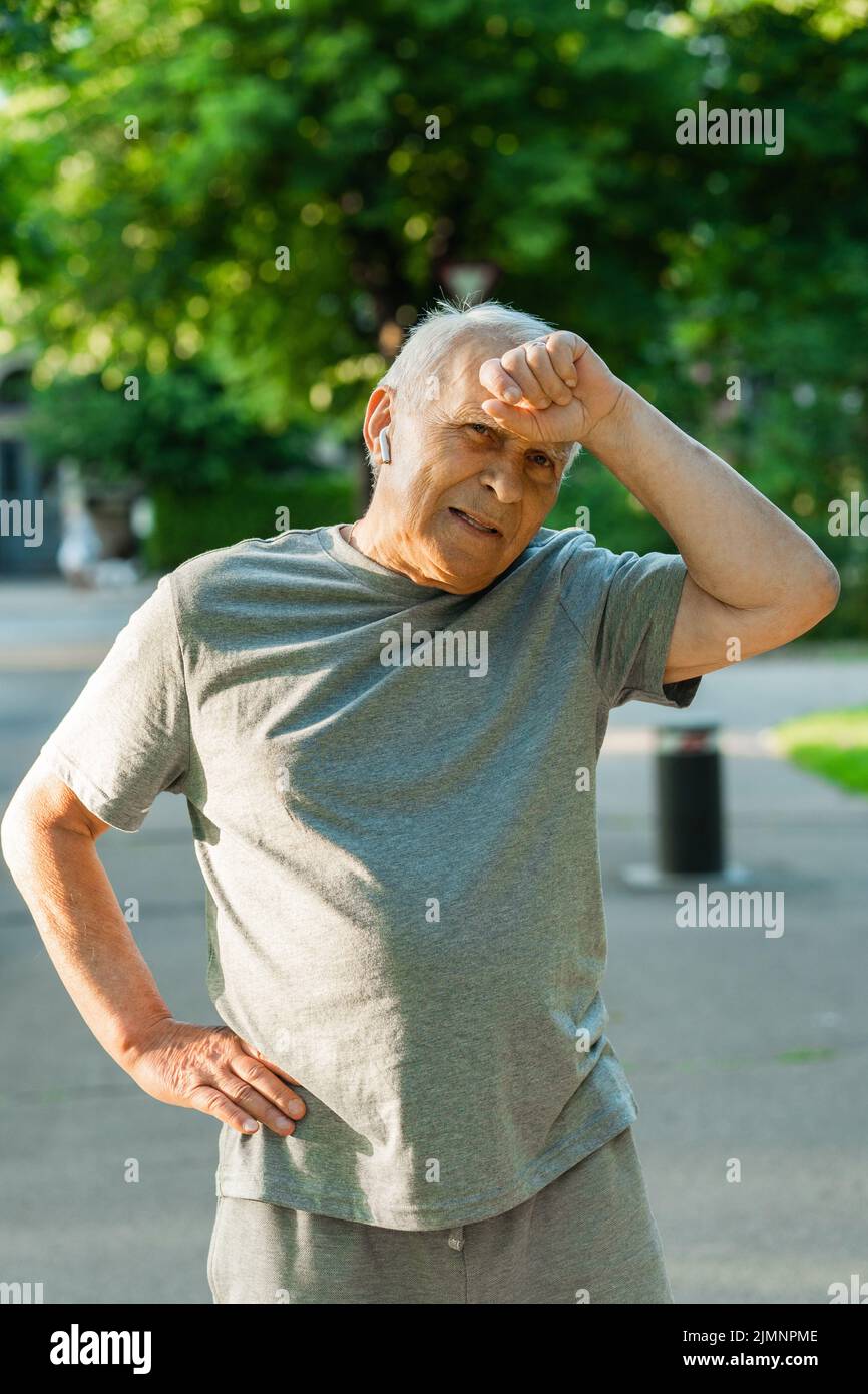 Uomo anziano esausto dopo il suo allenamento da jogging Foto Stock