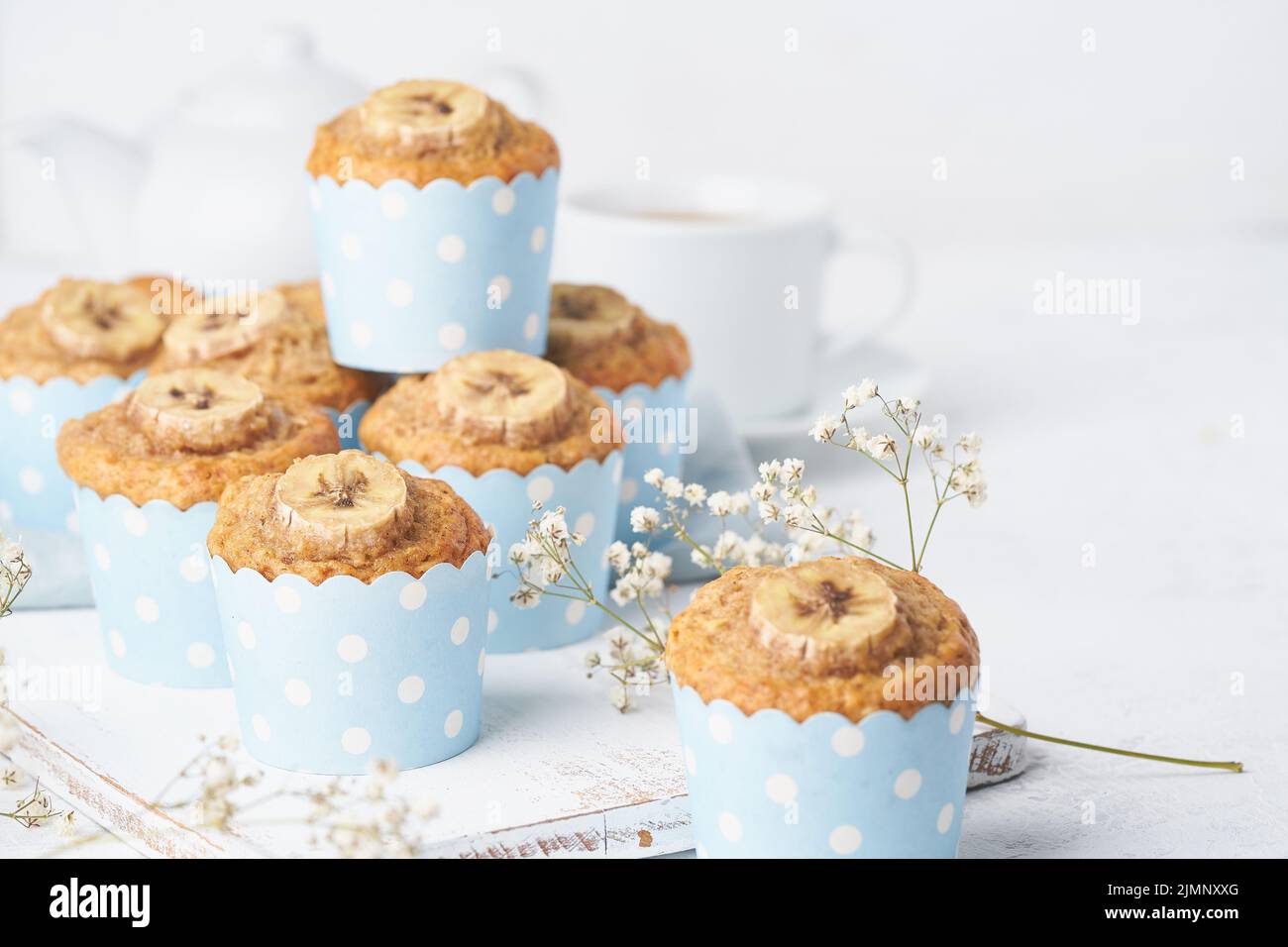 Muffin a banana in carta per dolci blu, vista laterale, primo piano, spazio copia. Colazione al mattino Foto Stock