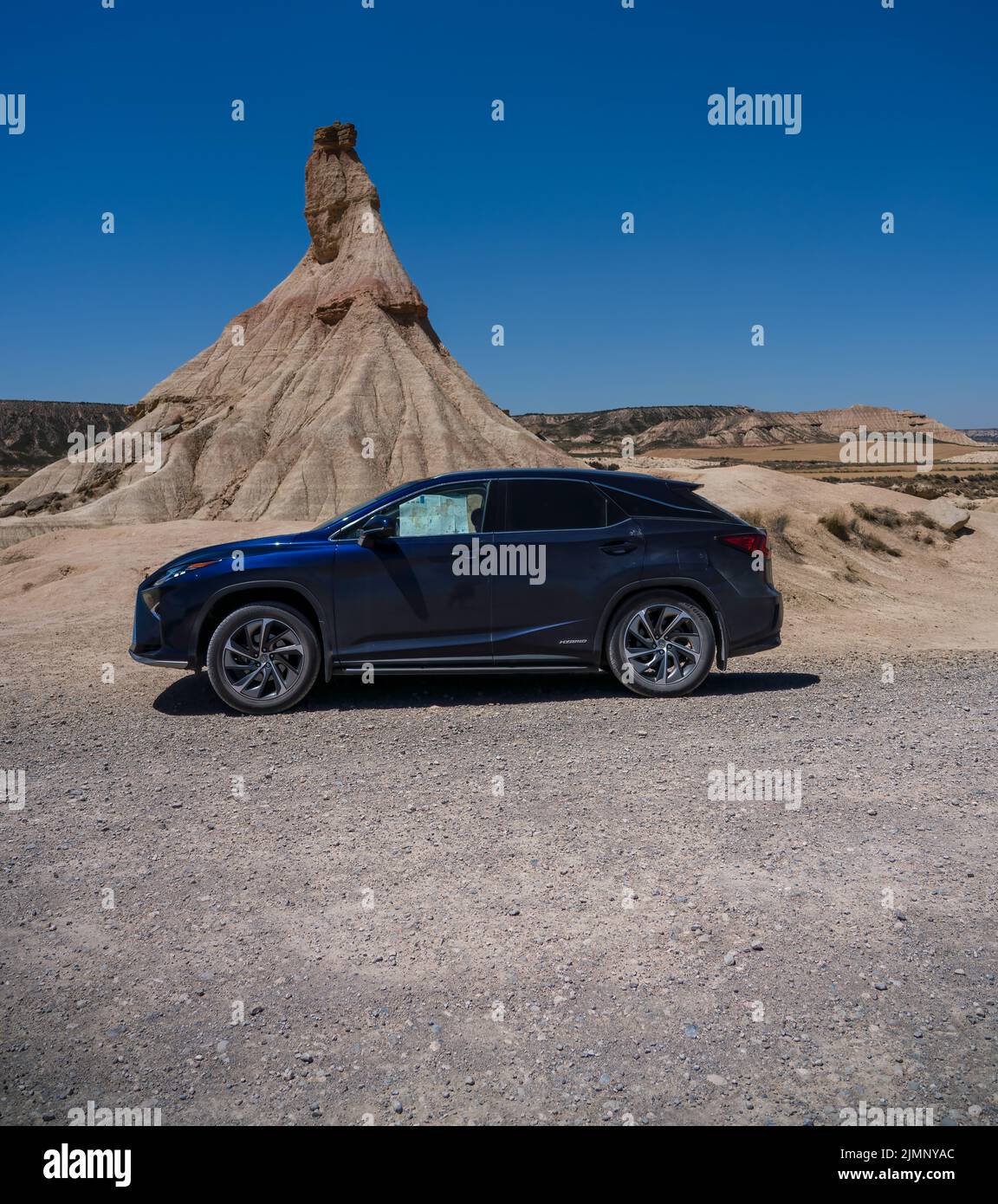 Blu Lexus RX450H di Castildeterra, statuesque in una regione naturale semi-desertica o Badlands che compongono argilla, gesso e arenaria, Bardenas Reales, Spagna Foto Stock