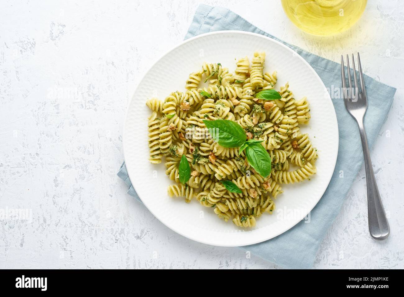 Fusili pasta con pesto di basilico ed erbe aromatiche, cucina italiana, sfondo in pietra grigia, vista dall'alto Foto Stock