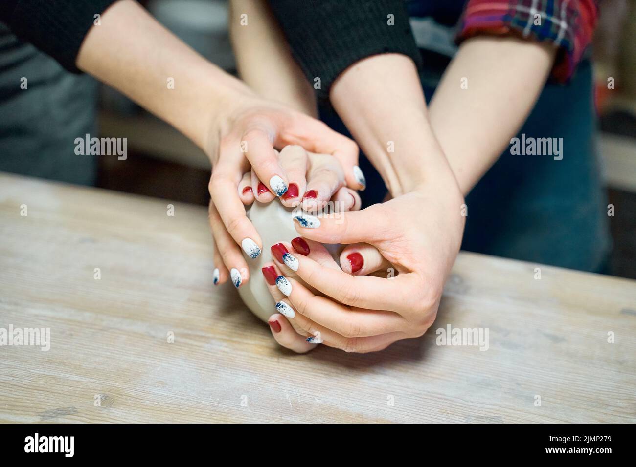 Donna che fa ceramica ceramica, quattro mani primo piano, fuoco su vasai, palme con ceramica, Foto Stock
