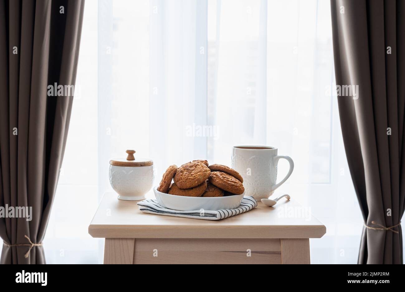 Colazione mattutina a base di caffè e biscotti su un tavolo di legno in camera da letto Foto Stock