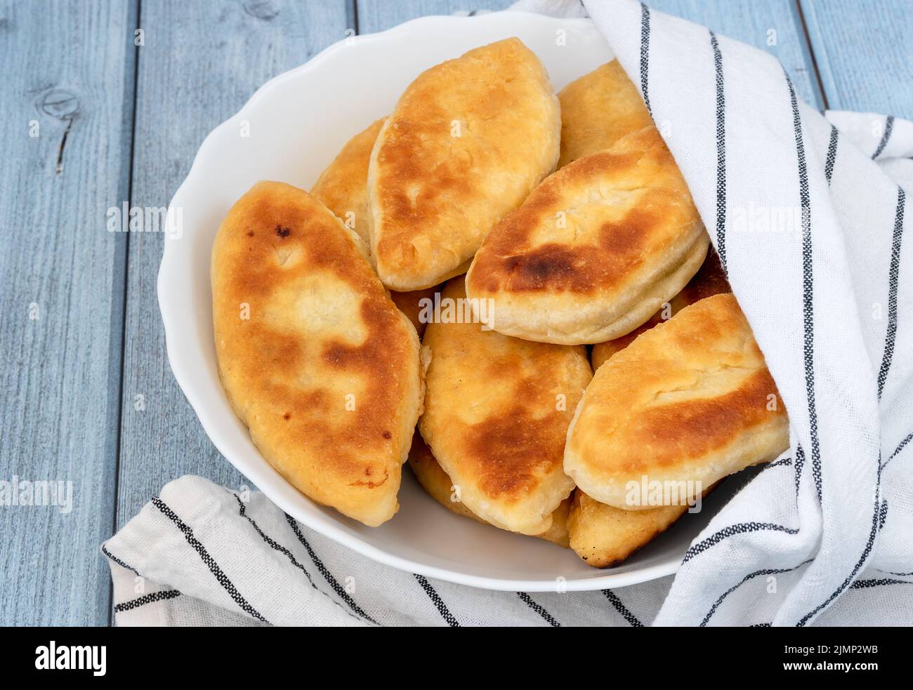 Lussureggianti torte di carne fritte su sfondo di legno blu Foto Stock