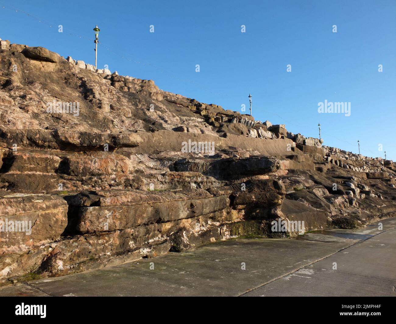 L'area delle scogliere di blackpool con rocce scolpite artificialmente e passerelle lungo il lungomare alla luce del sole del pomeriggio Foto Stock