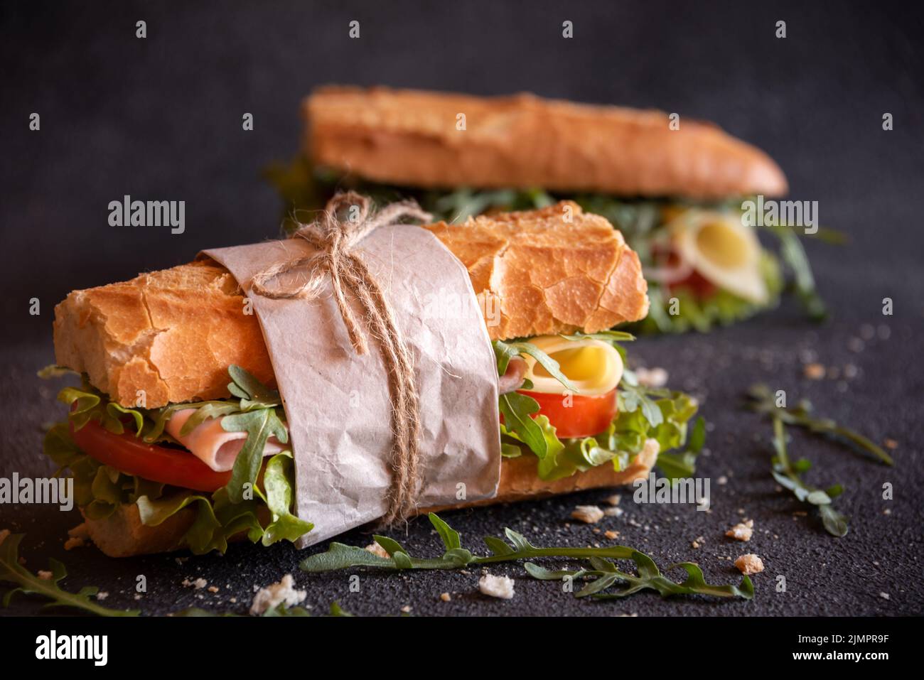 Sandwich baguette con formaggio, prosciutto, pomodori e verdure Foto Stock