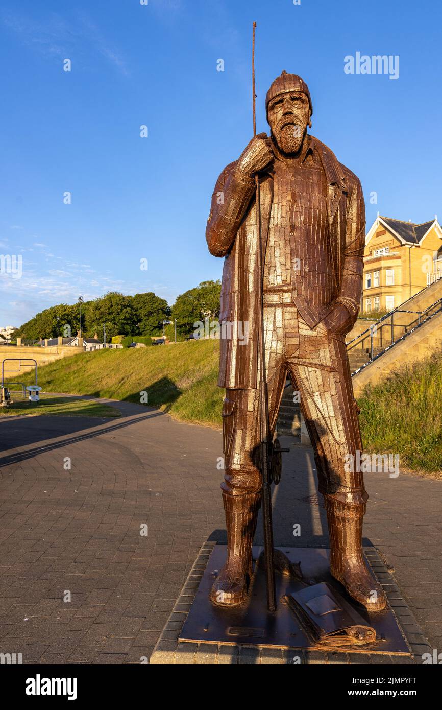 Una High Tide in Short Wellies, una scultura di Ray Lonsdale di un pescatore che si erge alto e orgoglioso sul lungomare di Filey, North Yorkshire. Foto Stock