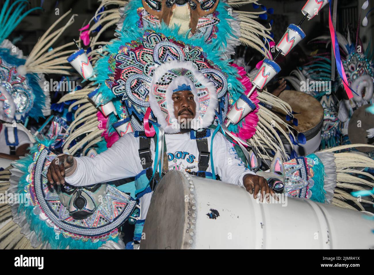 Uomini che battono tamburi e trombe soffiano in costumi colorati per la sfilata di carnevale di strada di junkanoo Foto Stock