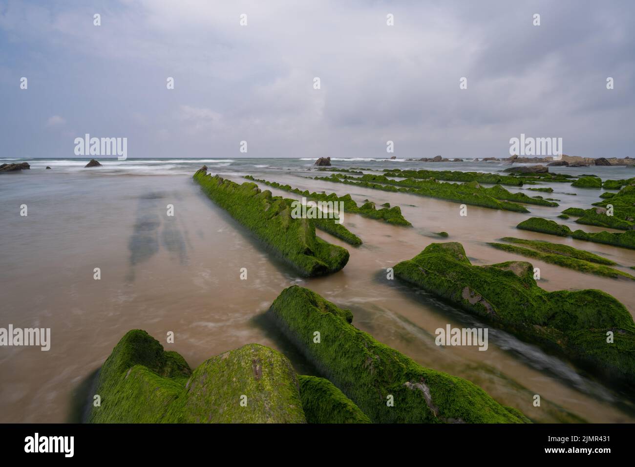 Una lunga esposizione delle formazioni rocciose di Flysch con la bassa marea alla spiaggia di Barrika vicino Bilbao Foto Stock