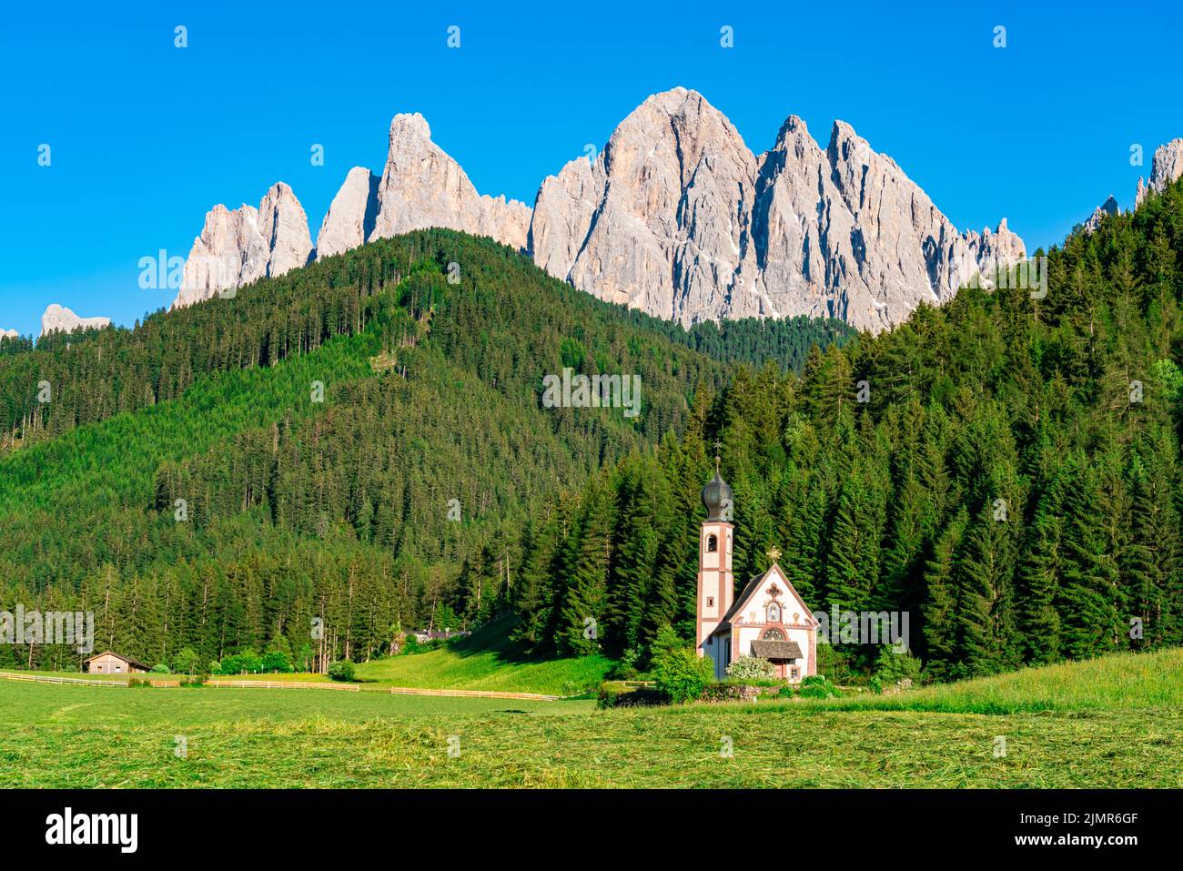 Chiesa di San Giovanni di Nepomuk di fronte al monte Odle nella Valle delle Dolomiti di Funes. Foto Stock