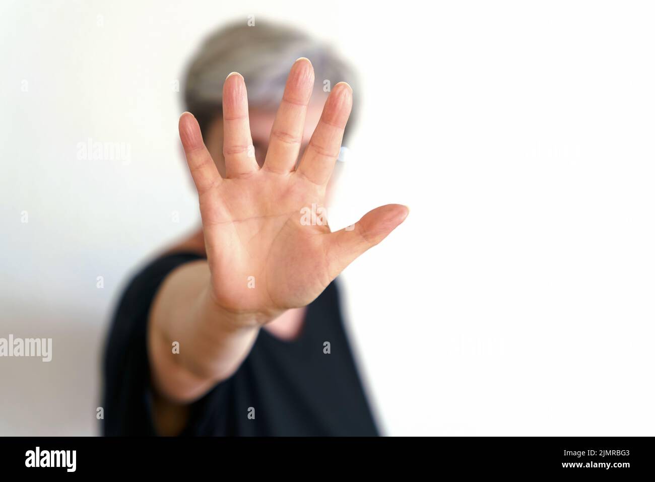 Una donna si protegge con un movimento difensivo della mano Foto Stock