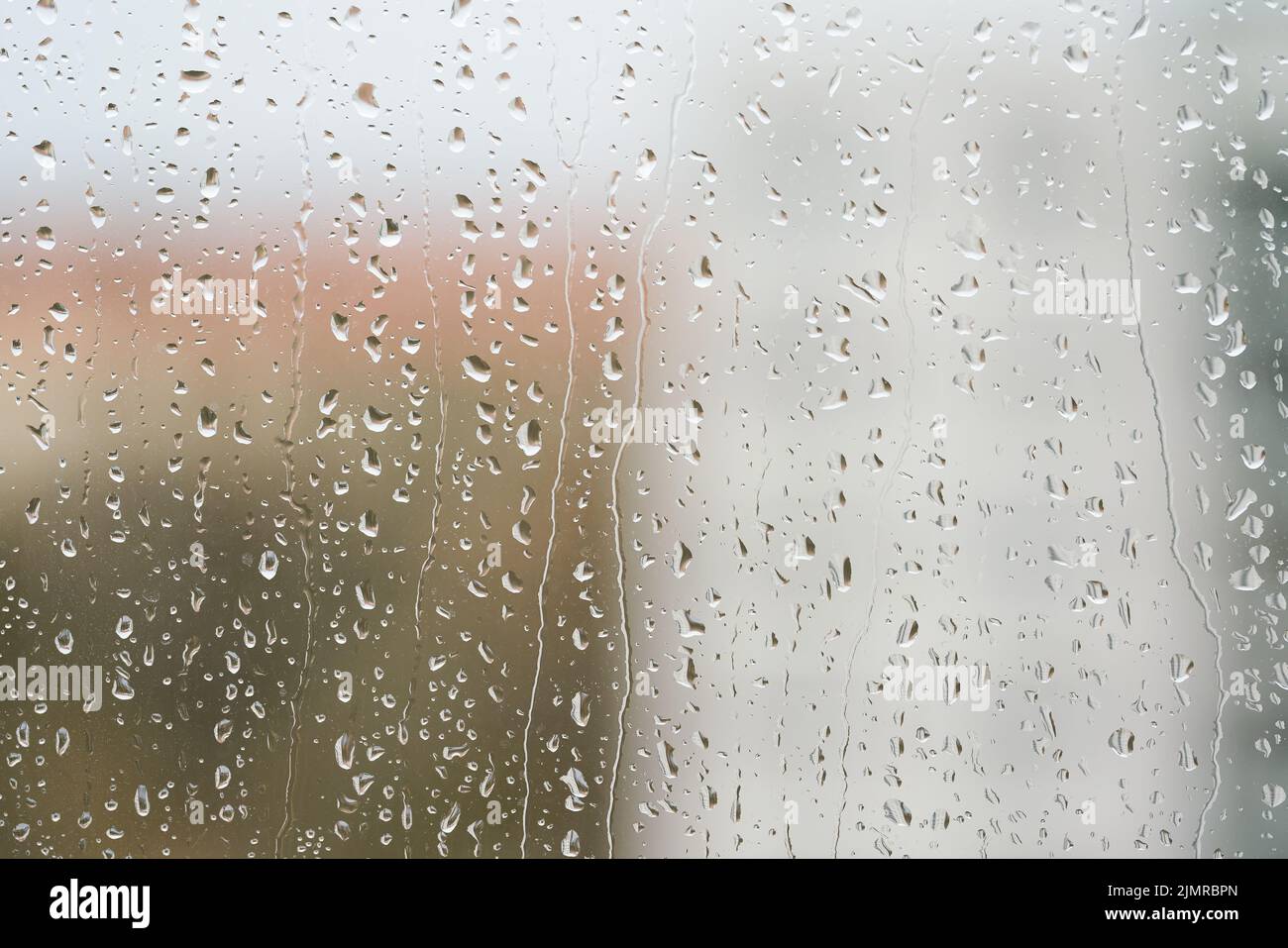 Pioggia su un pannello della finestra durante il tempo piovoso Foto Stock