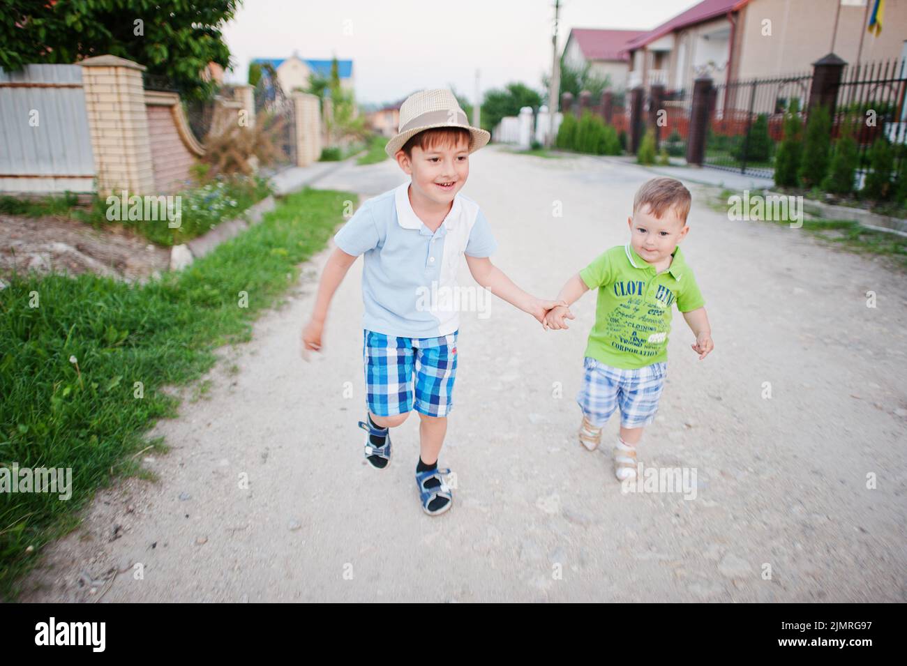 Due fratelli che camminano tenendo le mani, fratello amore. Foto Stock