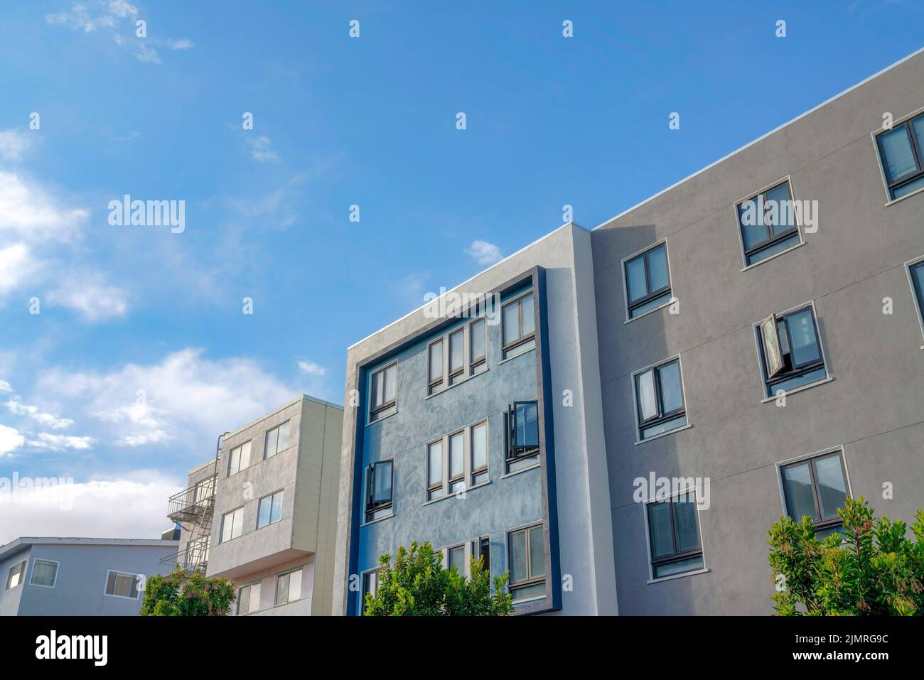 Moderni edifici di appartamenti con esterni grigi, blu e bianchi a San Francisco, California. C'è un edificio di appartamenti sulla sinistra con emergenza Foto Stock