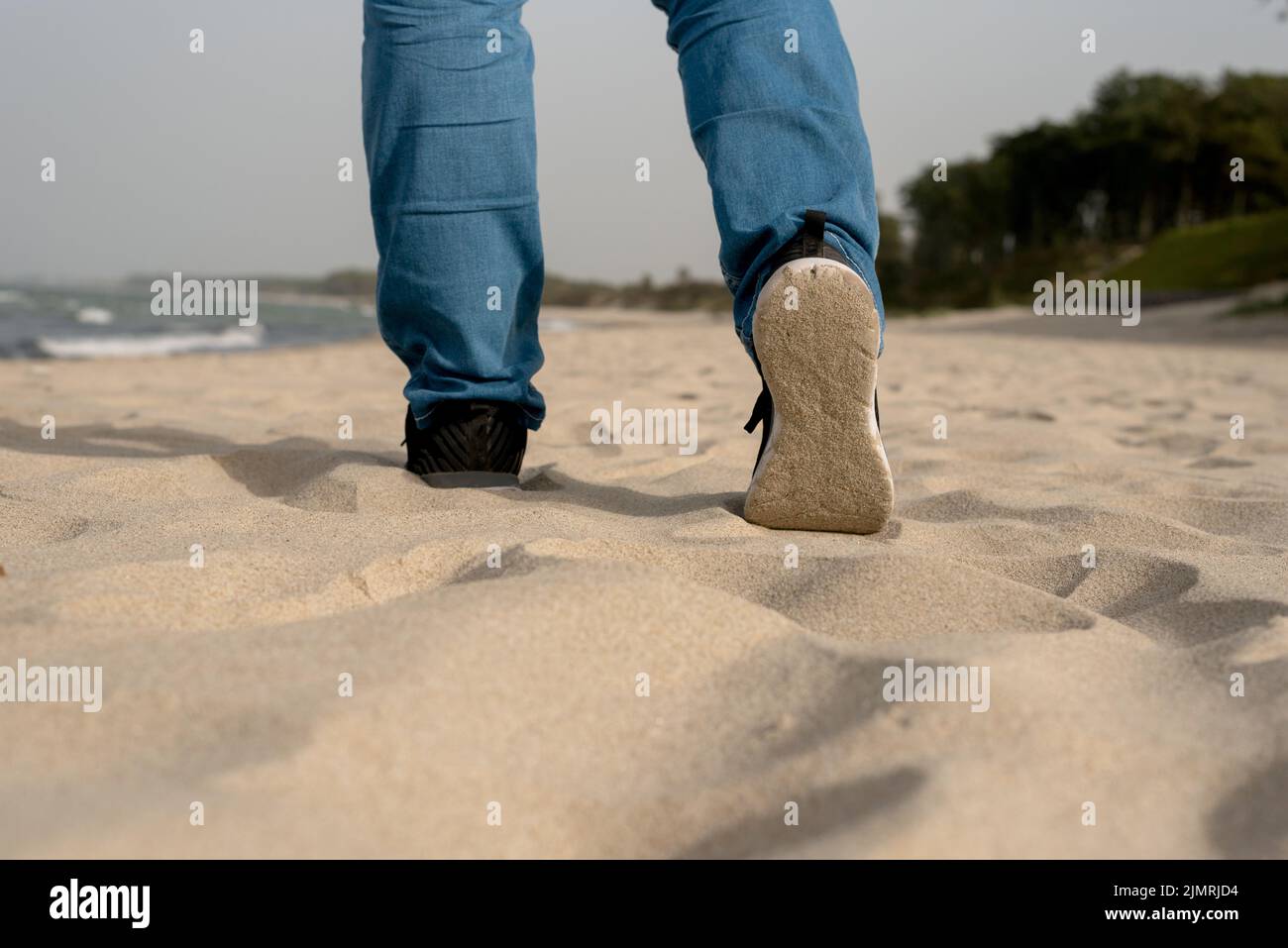 Gambe di un uomo sulla spiaggia Foto Stock