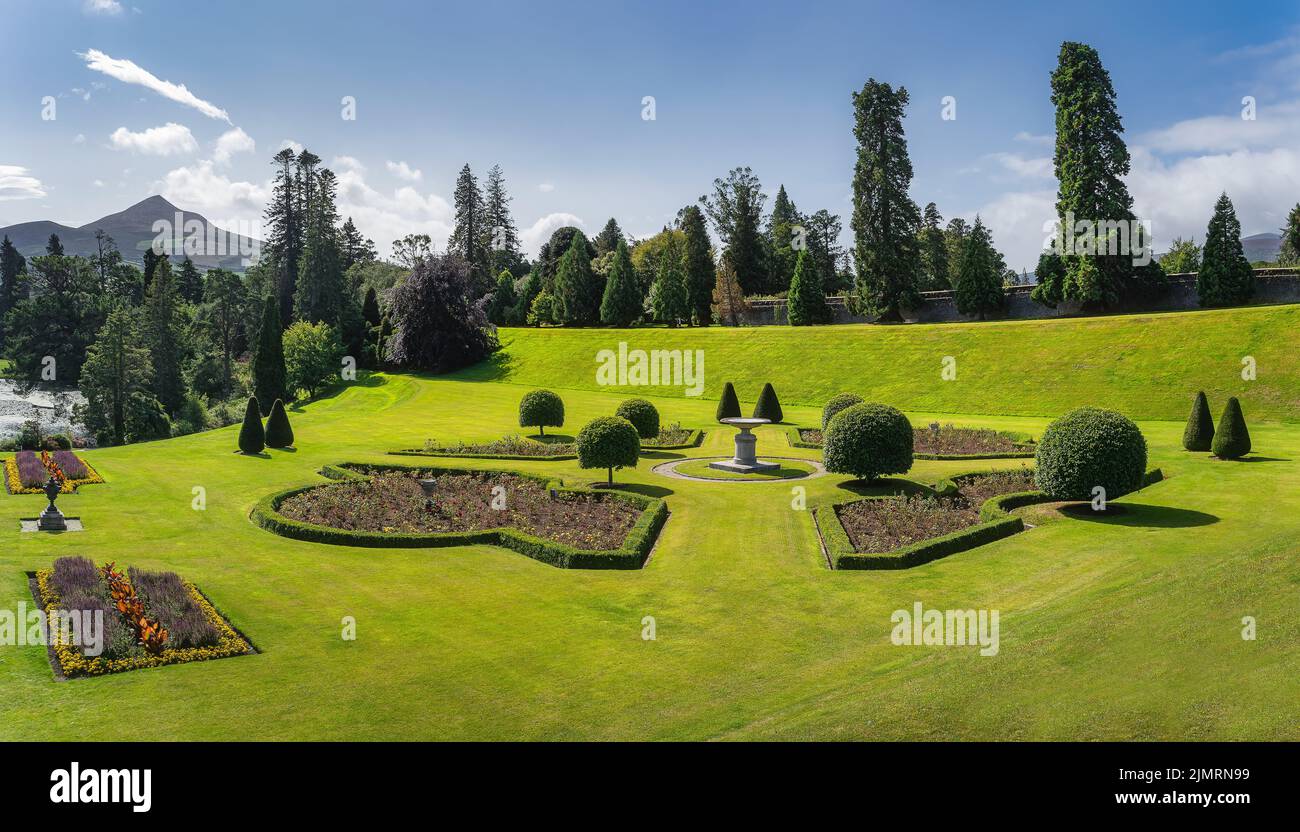 Giardino Powerscourt con aiuole, siepi e alberi. Pan di zucchero sullo sfondo, Irlanda Foto Stock