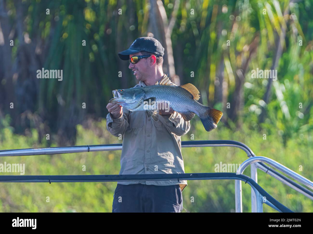 Pescatore che detiene un barramundi in famose acque Gialle Billabong, Kakadu National Park, Northern Territory, Australia Foto Stock