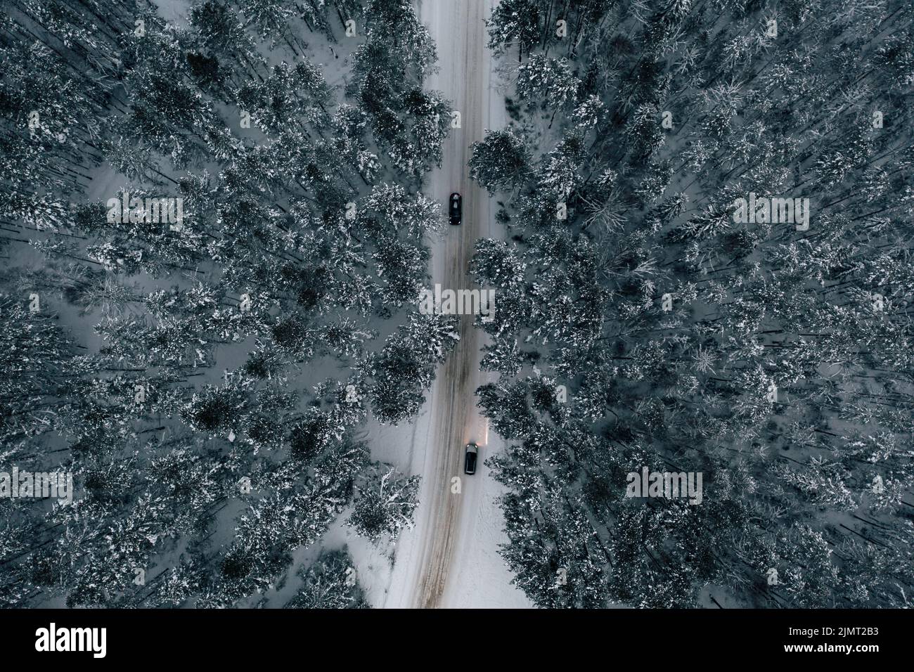Veduta aerea della strada innevata con auto, foresta invernale Foto Stock