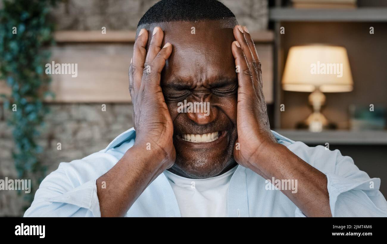 Ritratto di annoiato afroamericano uomo adulto arrabbiato anziano anziano businessman grida NON copre orecchie con mani molto rumore sente attacco di panico Foto Stock
