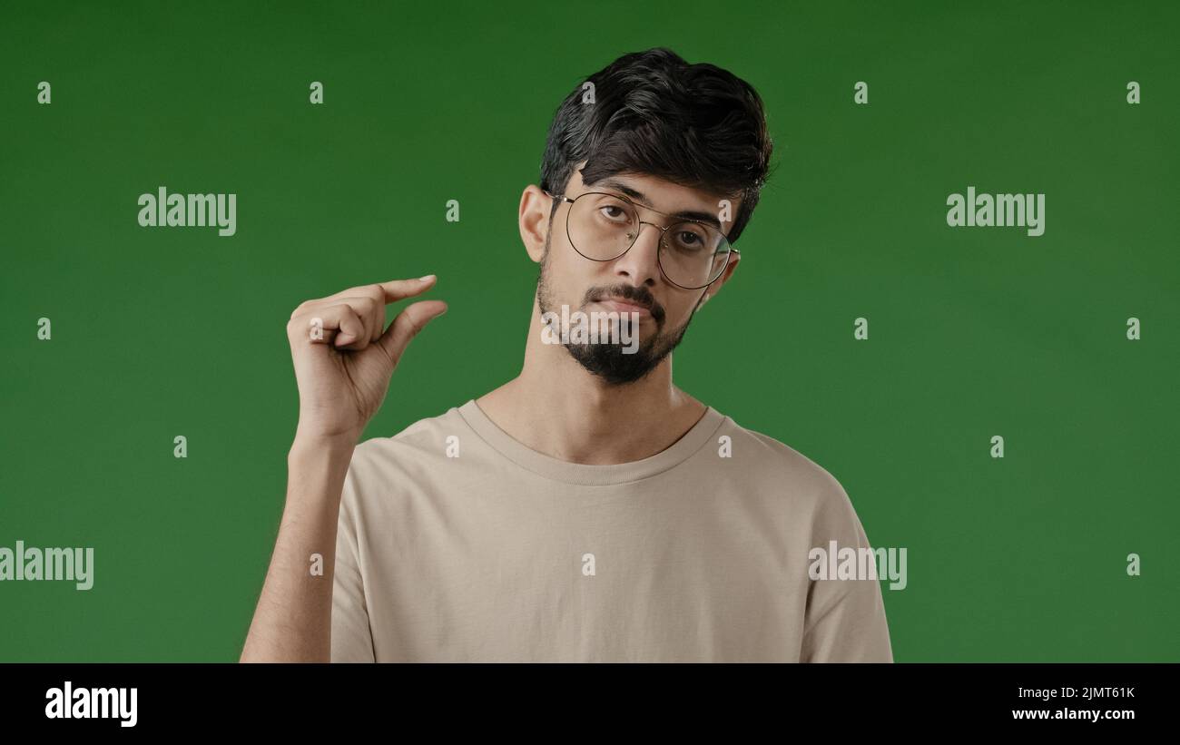 Deluso bruna infelice uomo arabo fare piccolo gesto punta con le dita tipo insoddisfatto mostra piccola forma di dimensioni basso rating di misurazione pollici piccolo Foto Stock