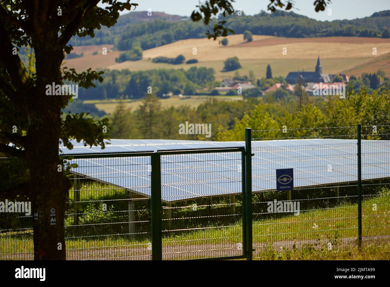 sistema solare dietro una recinzione, sullo sfondo un piccolo villaggio Foto Stock