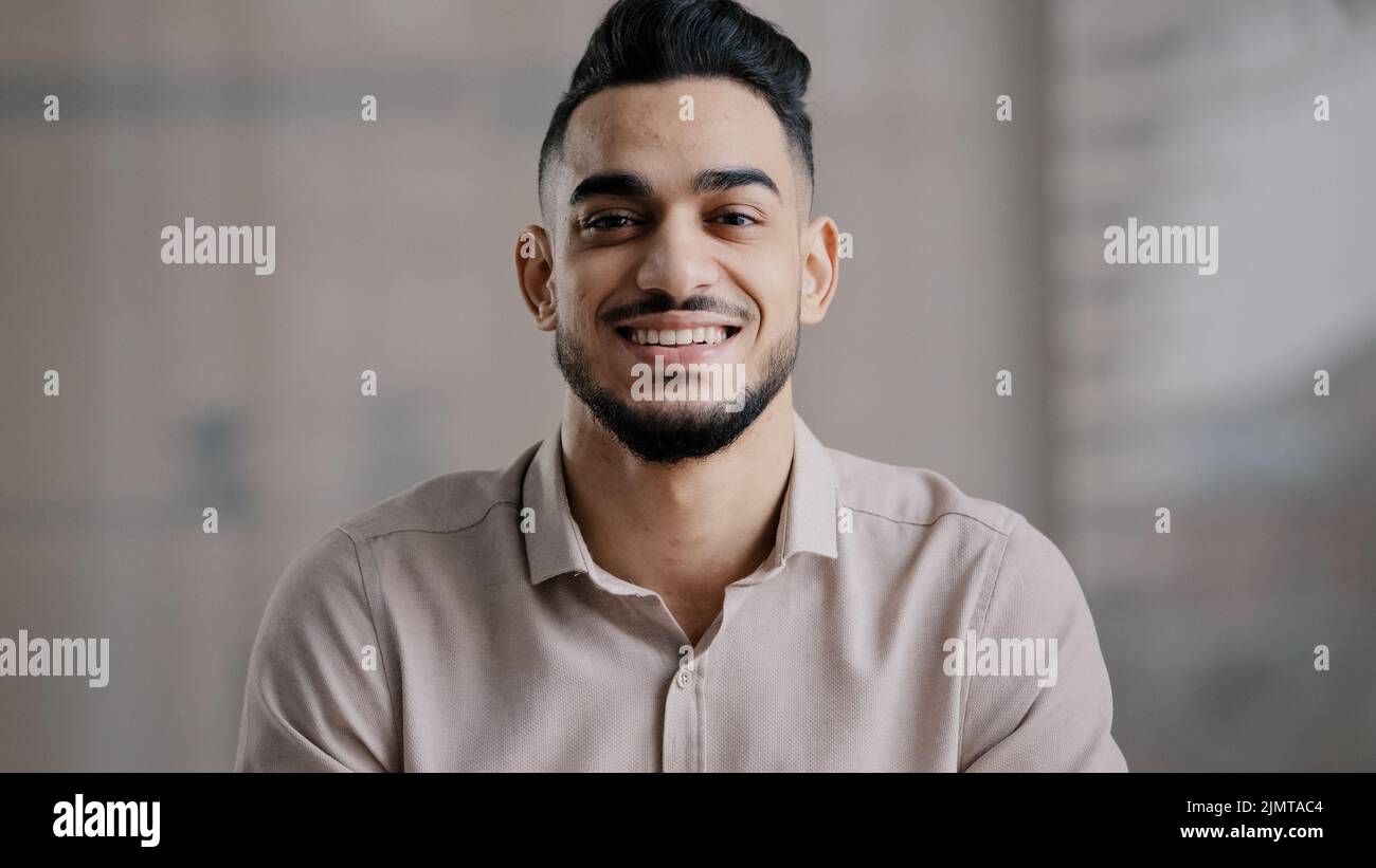 Felice ragazzo gioioso ispanico arabo bello giovane uomo modello casual con sorriso toothy guardare fotocamera ottimista volto maschile ritratto sorridente uomo d'affari Foto Stock