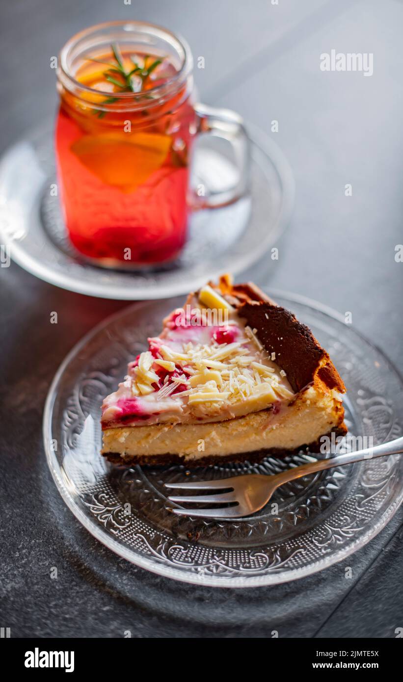 Cheesecake e un bicchiere con bevanda calda a base di frutta Foto Stock